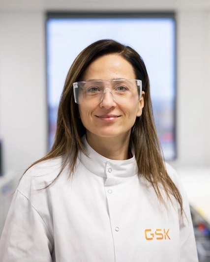 Lab scientist wearing safety glasses looking at camera